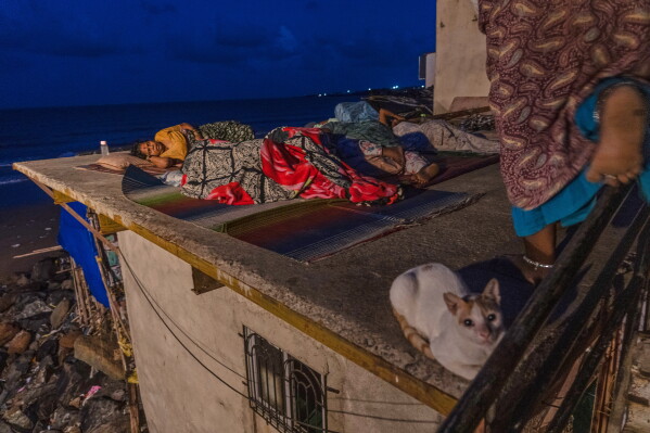 Residents sleep on the roof of their home near Versova Beach to escape the oppressive heat inside as hot and humid conditions persist amid a delayed monsoon in Mumbai, India, June 19, 2026. (AP Photo/Rafiq Maqbool, File)