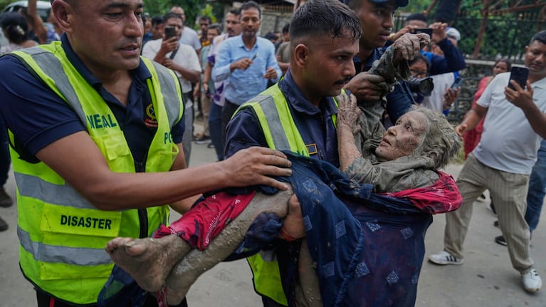 Rescuers carry a victim of flash flooding to safety along the Trishuli River in Nepal's Nuwakot district