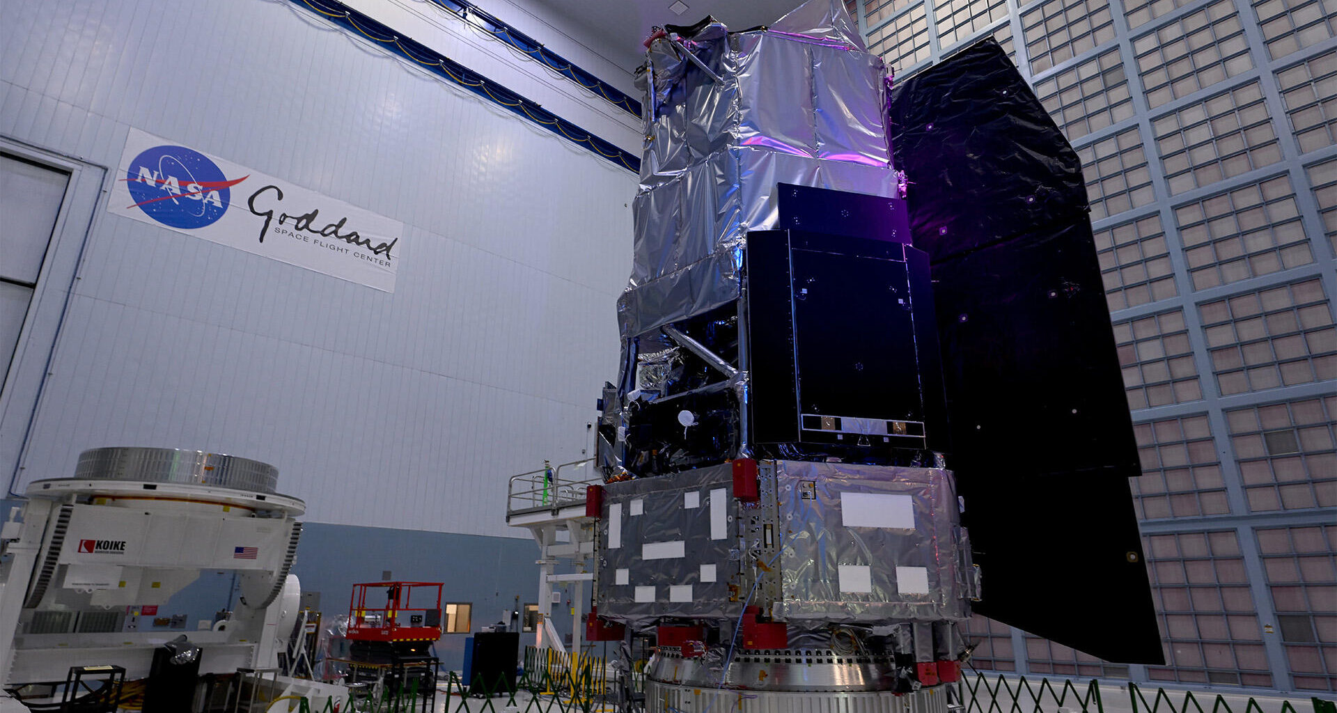 The boxy structure of the Nancy Grace Roman Space Telescope stands in a high-ceiling bay in a NASA facility.