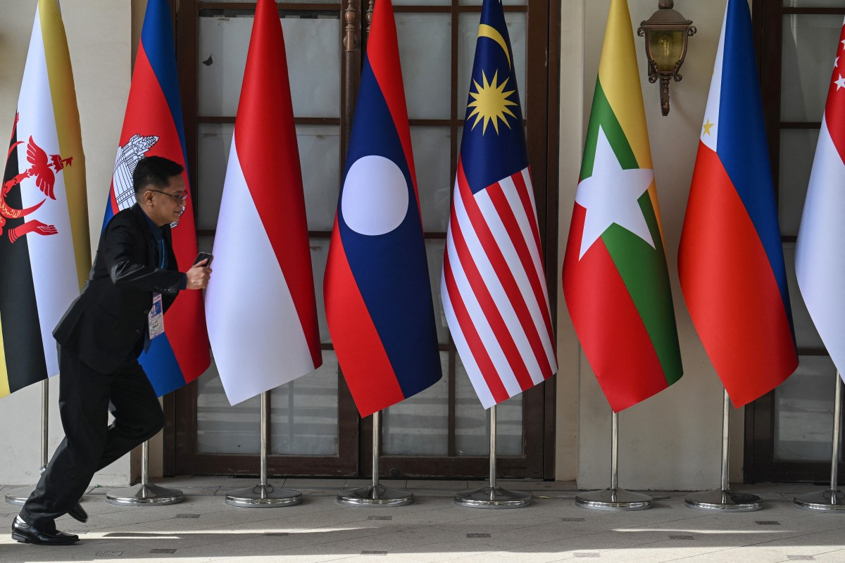 A man runs past national flags of ASEAN member states on May 5 outside a media center in Cebu, the Philippines, ahead of the 48th ASEAN Summit.