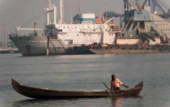 Small fishing boat in front of large boat