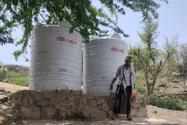 Abdulaziz Shamsan stands beside water tanks near the camp for displaced families where he lives [Courtesy of Abdulaziz Shamsan]