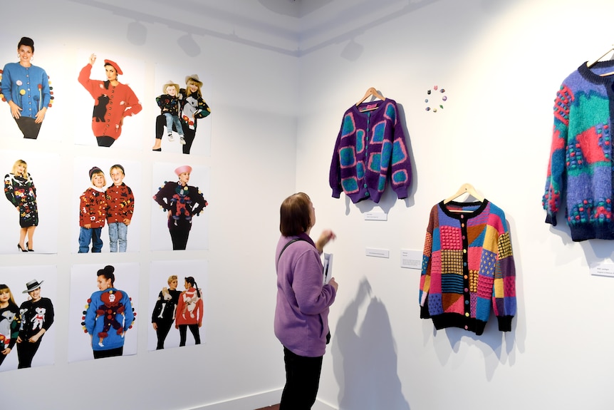 A woman looks at jumpers mounted at the South Australian Living Artists festival.