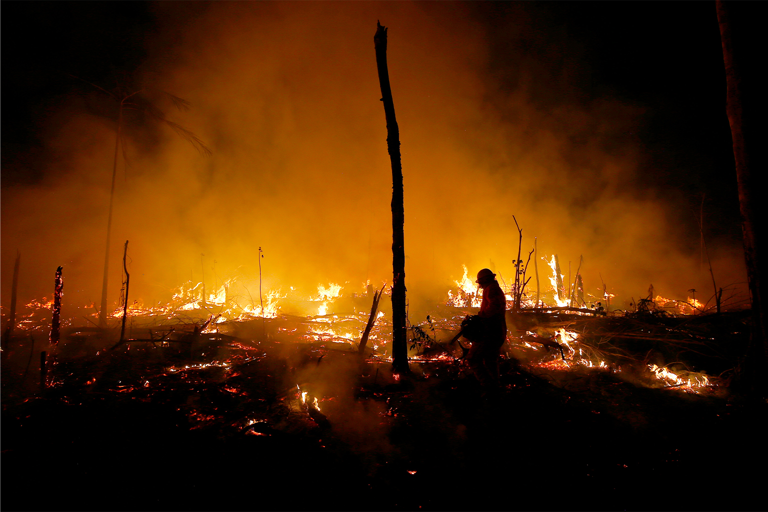 Firefighters work to put out a blaze in the Amazon forest during a drought and high temperatures in the rural municipality of Careiro Castanho, Amazonas state, Brazil. Image by AP Photo / Edmar Barros.