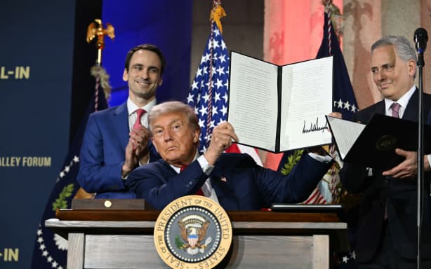 US President Donald Trump displays an executive order on artificial intelligence he signed at the "Winning the AI Race" AI Summit at the Andrew W. Mellon Auditorium in Washington, DC, on July 23, 2025. (Photo by ANDREW CABALLERO-REYNOLDS / AFP)