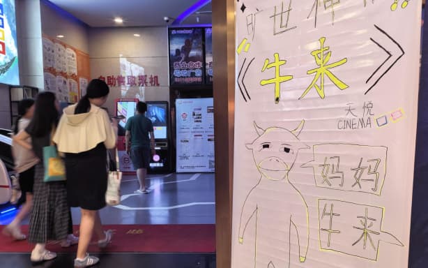 A hand-drawn poster for the film "Niu Lai" is displayed at the entrance of a cinema in Beijing, on 21 August, 2026. The film is currently in theaters.