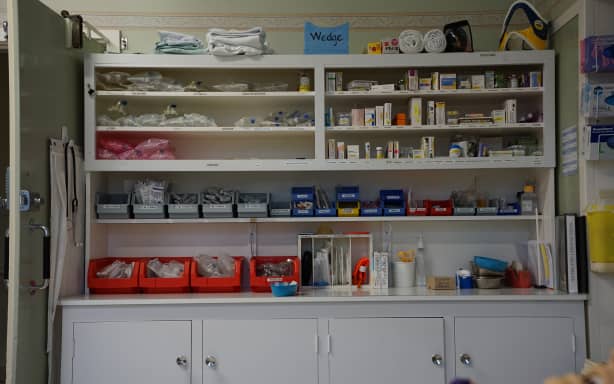 A shelf of medications and medical tools that could come in handy when treating a rural patient.