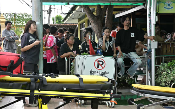 Parents and students gather outside a school following a shooting in Bang Kruai district, Nonthaburi province, north of Thailand's capital Bangkok, on August 7, 2026. Two people were killed and 15 wounded in a school shooting in a province just north of the Thai capital Bangkok on August 7, local media reported. (Photo by Lillian SUWANRUMPHA / AFP)