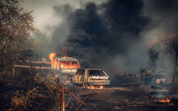 This handout photo released on July 26, 2026 and taken on July 24, 2026 by Spain's Military Emergencies Unit (UME) shows vehicles in flames during a wildfire near Navas del Rey, 55 kilometers southwest of Madrid. Spain faces two crucial days to bring raging wildfires under control before weather conditions worsen, authorities said on July 27, 2026, though they were making some progress and planned to start returning evacuees to certain areas. The wildfires that broke out in forested areas around the Spanish capital at the height of the summer holidays have forced some 60,000 people to flee their homes, often with just minutes' notice, leaving pets and medicine behind. (Photo by Handout / UME / AFP) / RESTRICTED TO EDITORIAL USE - MANDATORY CREDIT "AFP PHOTO / SPAIN'S MILITARY EMERGENCIES UNIT (UME) / HANDOUT" - NO MARKETING NO ADVERTISING CAMPAIGNS - DISTRIBUTED AS A SERVICE TO CLIENTS