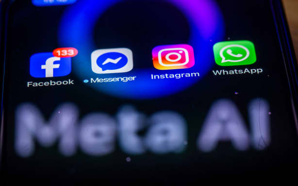 ILLUSTRATION - 27 May 2025, Mecklenburg-Western Pomerania, Schwerin: The Facebook, Messenger, Instagram and WhatsApp apps are shown on a smartphone display that reflects the logo of the AI application Meta AI. The Facebook group Meta can now start training its artificial intelligence systems on a large scale with user data from Germany. Photo: Jens Büttner/dpa (Photo by JENS BUTTNER / dpa Picture-Alliance via AFP)