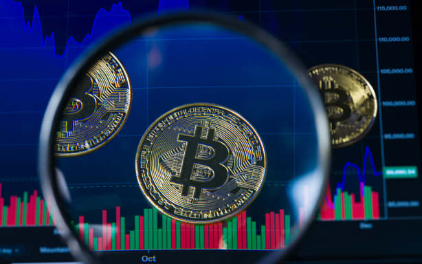 Tokens representing Bitcoin are placed on a screen showing a declining cryptocurrency chart, as Bitcoin trades around $89,635 against the U.S. dollar, in this photo illustration in Brussels, Belgium, on December 6, 2025. (Photo by Jonathan Raa/NurPhoto) (Photo by Jonathan Raa / NurPhoto via AFP)