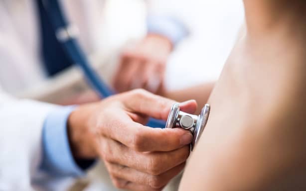 Doctor using stethoscope in examining a small boy