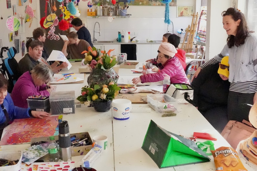 People making art around a large table,