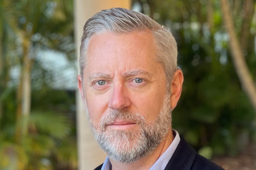 Head shot of a man with a beard in a suit jacket.