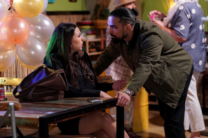 Ravi leans over Priya in a scene from EastEnders