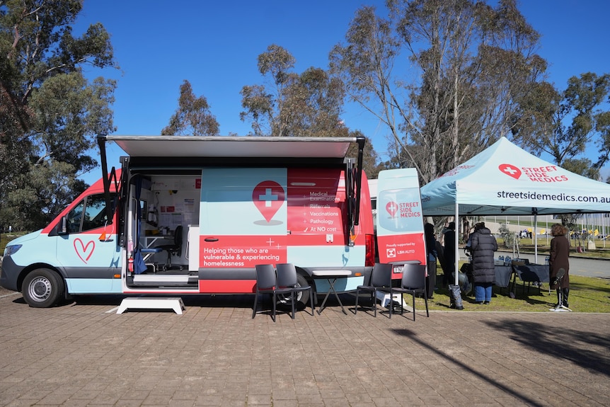 A van and signage stands on a street in Canberra.