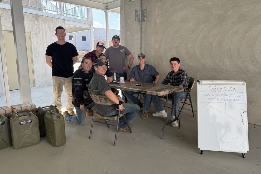 Young men sitting at a table in a concrete building