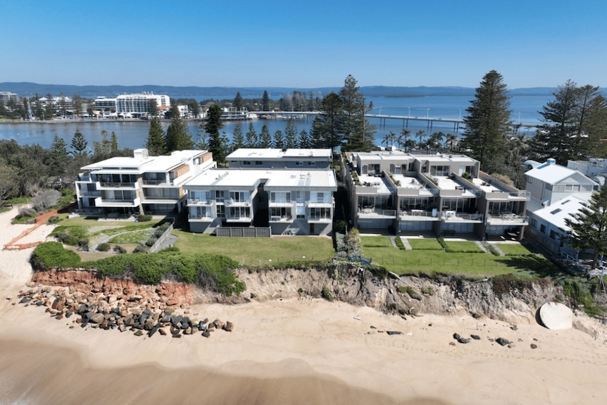 Aerial view of an eroded beach embankment with homes built on top.