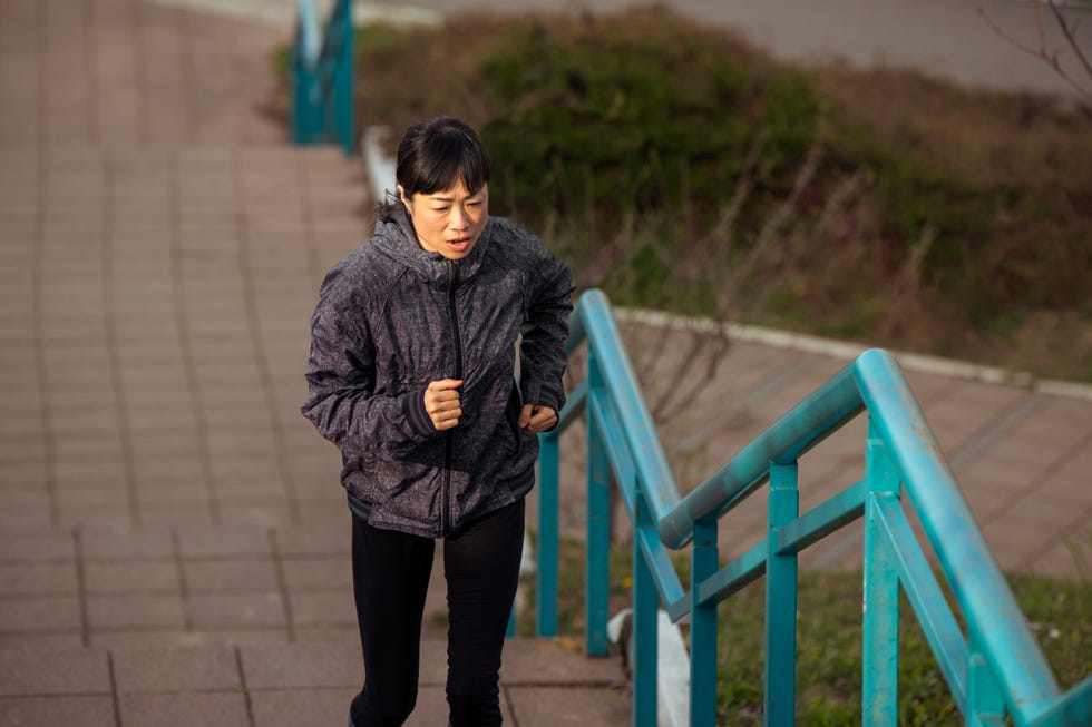 best exercise routine for stronger bones: woman walking up some stairs in an urban environment