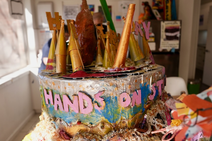 A brightly coloured cardboard cake on a table.