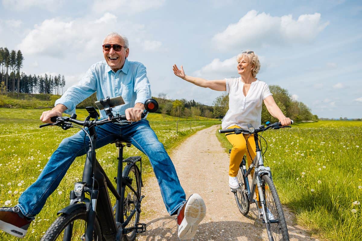 Seniors having fun on bicycles in spring landscape