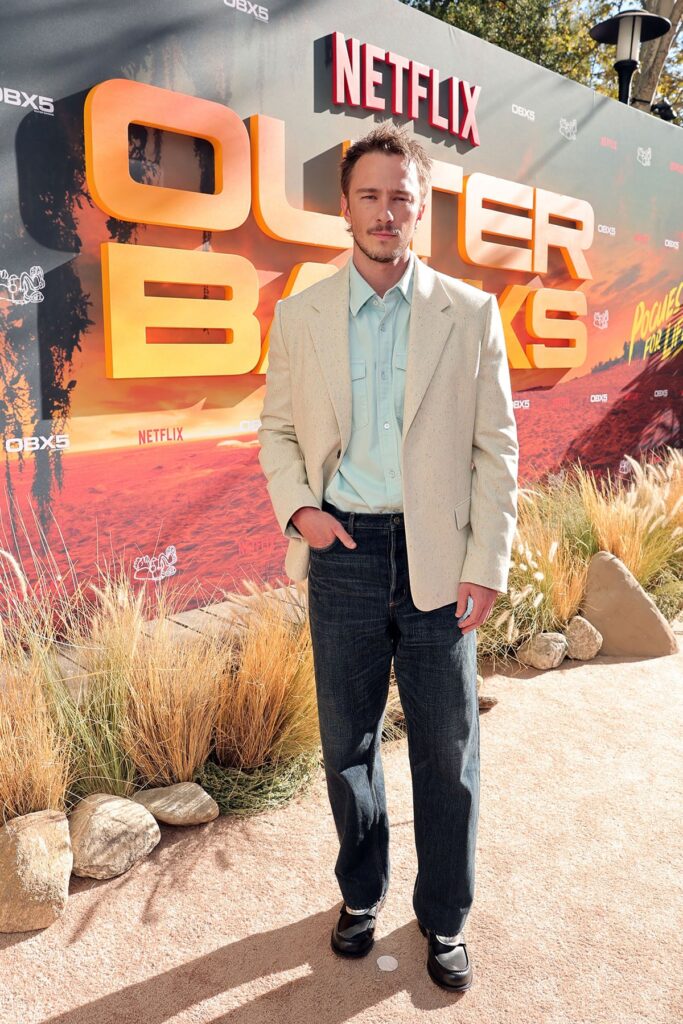 Drew Starkey wears Dior with an off-white blazer, pale blue shirt and dark jeans at the ‘Outer Banks’ Season 5 fan farewell in Los Angeles.