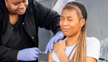 Clinical superviser Wyntre Jackson gives an immunization to Cianey Brown, 16, at a vaccination clinic this month during the School District of Philadelphia’s sixth annual Back-To-School Bus Tour stop at Marcus Foster Memorial Stadium.