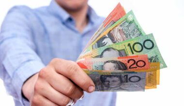 Man holding out Australian dollar notes, symbolising dividends.