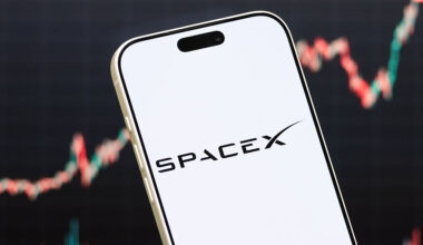 A phone with a SpaceX logo hovers in front of a fluctuating stock graph.