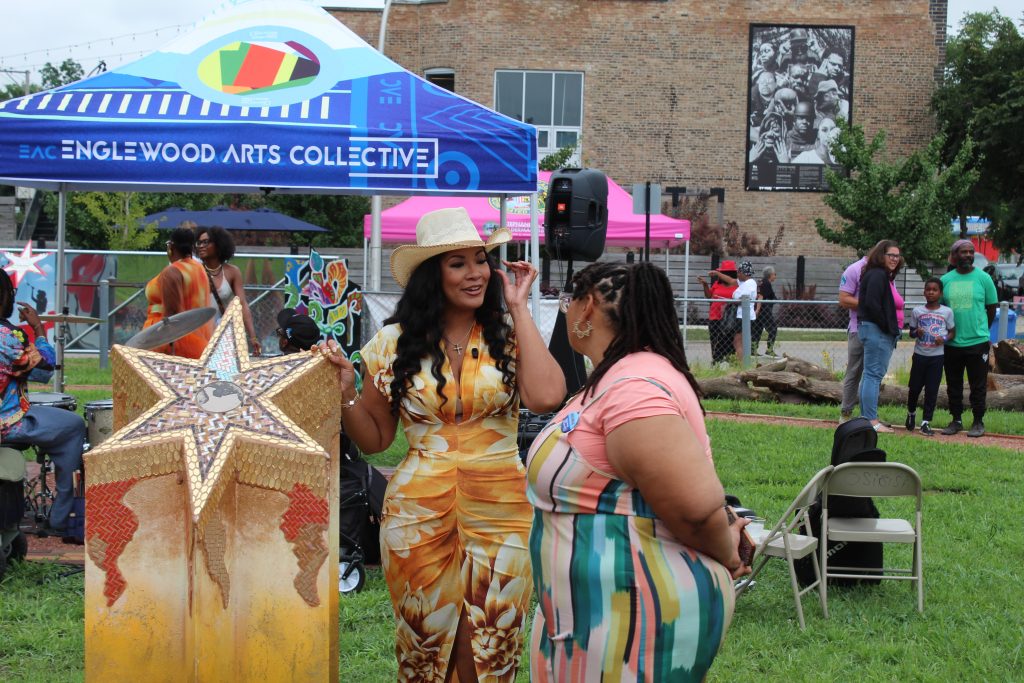 Ald. Stephanie Coleman (16th) stands next to a 'rising star' sculpture on display at the Arts Village Sculpture Park. Aug. 2, 2026.