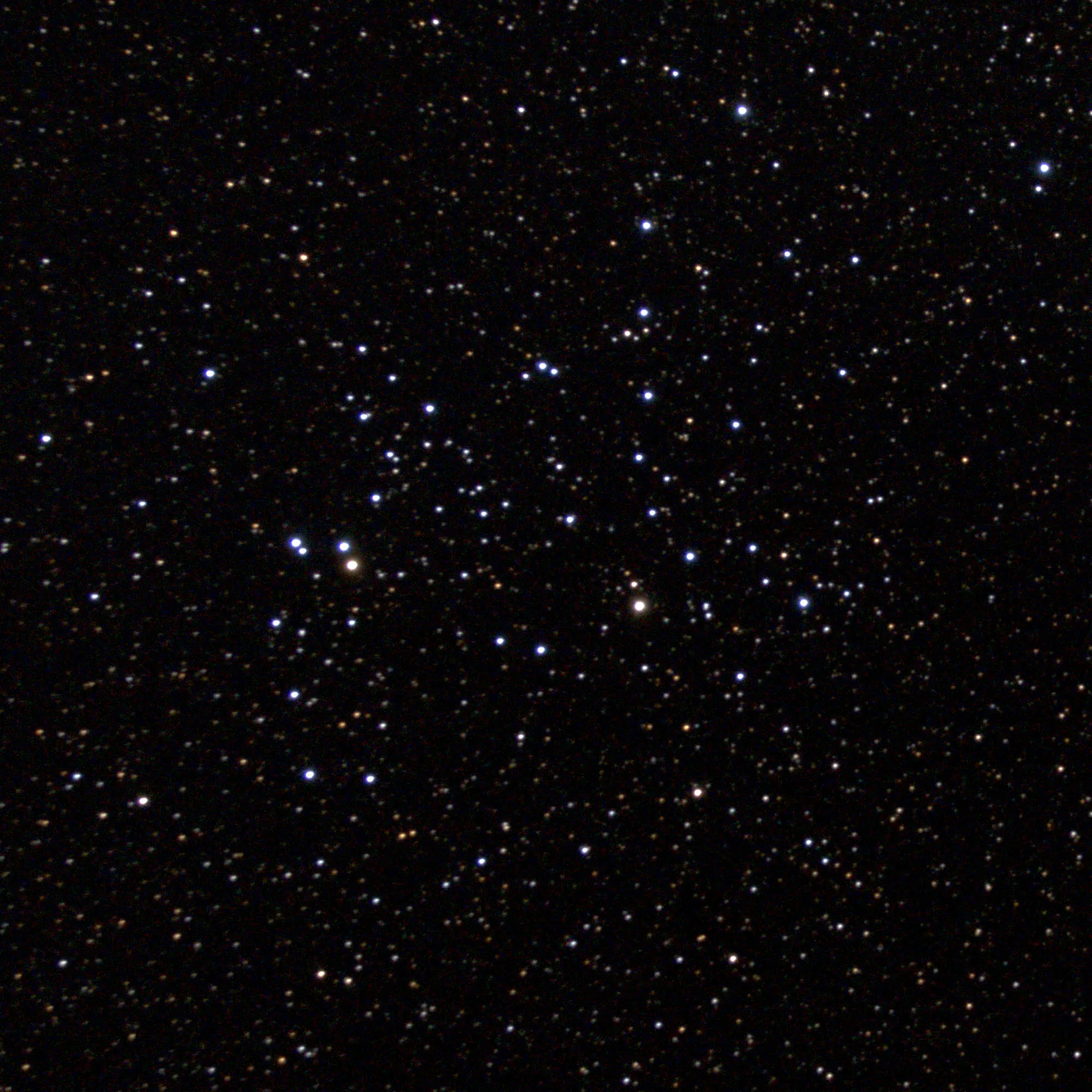 A telescopic photograph of NGC 6709, an open star cluster set against a dense, star-filled black sky. The cluster's members are scattered loosely across the frame, with a mix of bright blue-white stars and fainter orange and yellow background stars, and two noticeably brighter stars near the left-center of the cluster.