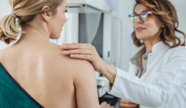 Female doctors checks the breast of another woman for signs of cancer