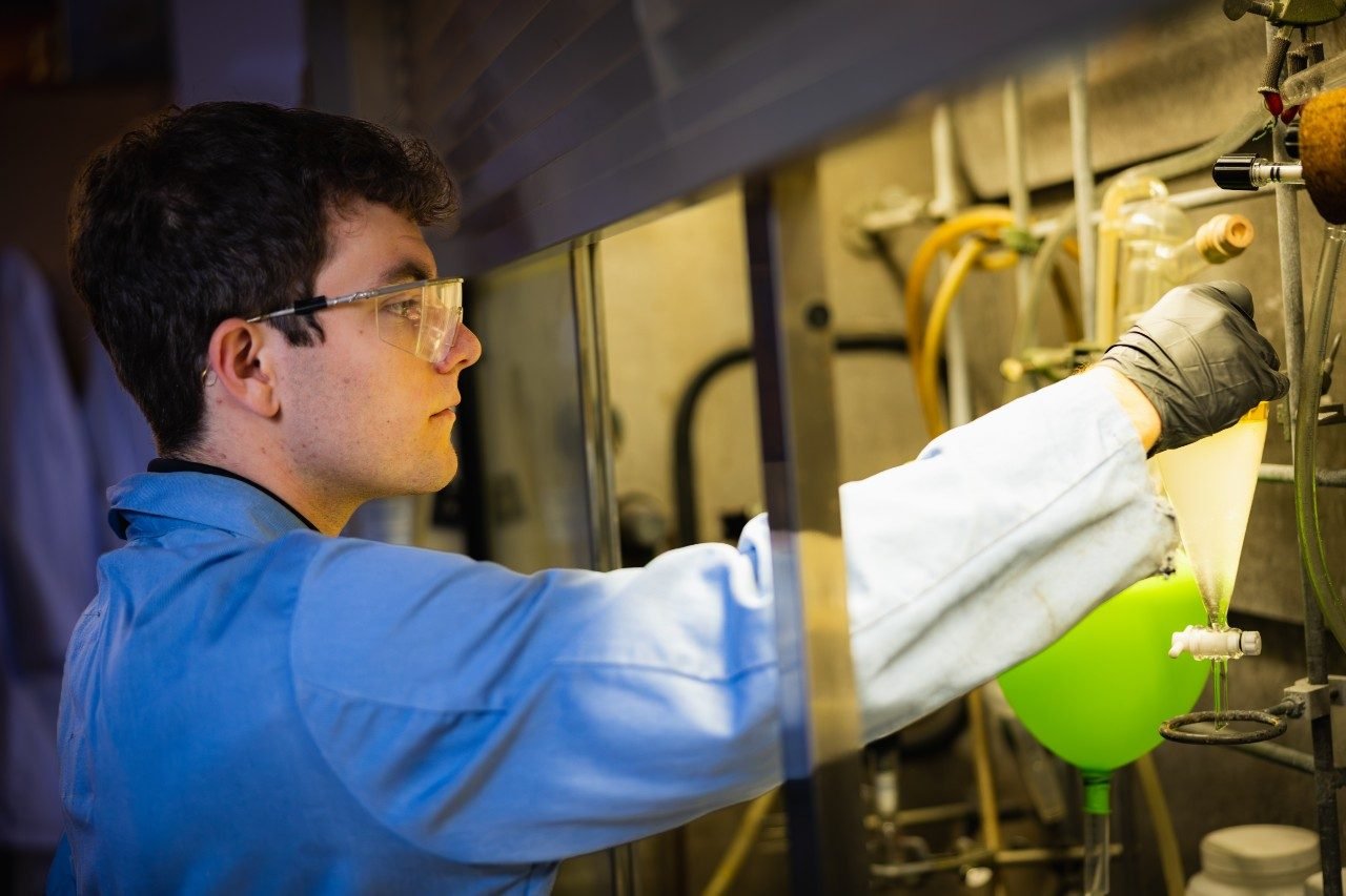 Graduate student Adrian DiMarco prepares a sample of engine oil created from upcycled plastic waste in Greg Liu's lab. Photo by Luke Hayes for Virginia Tech.
