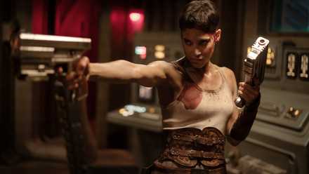 Sofia Boutella as Kora holding up guns