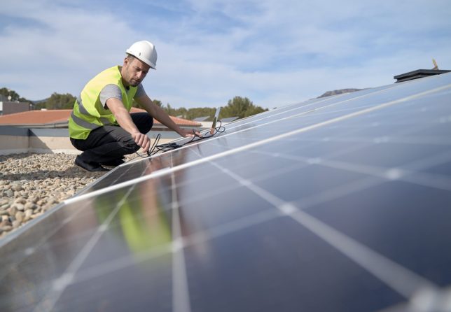 Engineer plugging in laptop cable wire to solar panels