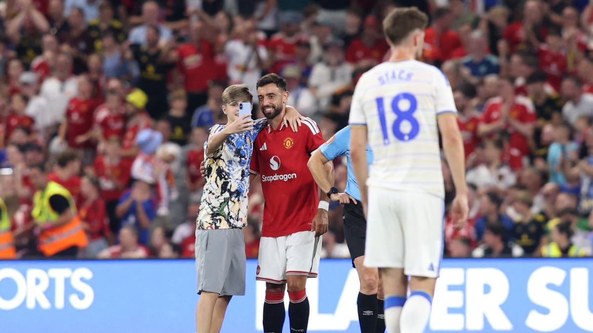 Pitch invaders take selfies with Bruno Fernandes during Manchester United friendly