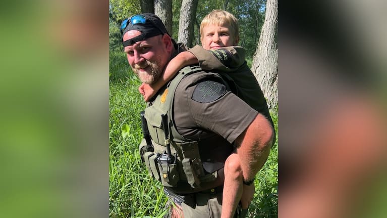 A boy with one of his rescuers. (Source: Michigan Department of Natural Resources)