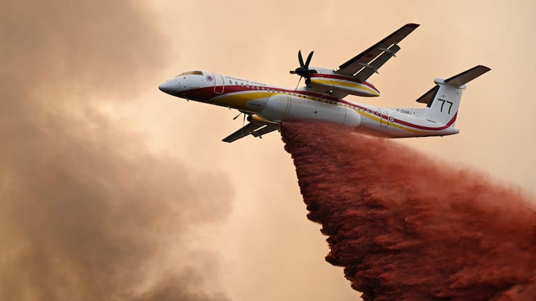 A De Havilland Canada Dash 8-400 drops fire retardant over a forest near Saint-Jean-d'Illac, during wildfires in southwestern France.