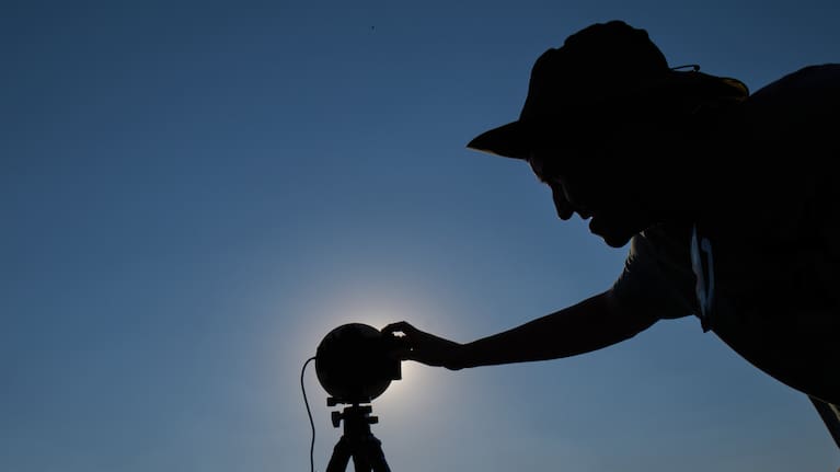 A member of the "Los Taraos" amateur astrophotography group, sets up his camera to shoot a total solar eclipse in Berlanga de Duero, central Spain.
