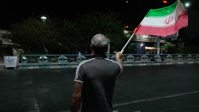 A pro-government demonstrator waves an Iranian flag in a gathering commemorating the late Iranian Supreme Leader Ayatollah Ali Khamenei at a square in Tehran, Iran.