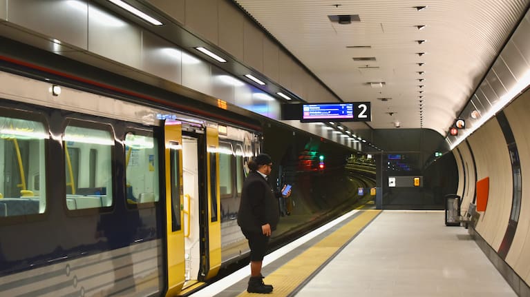 A train manager on the platform of Karanga-a-Hape station.
