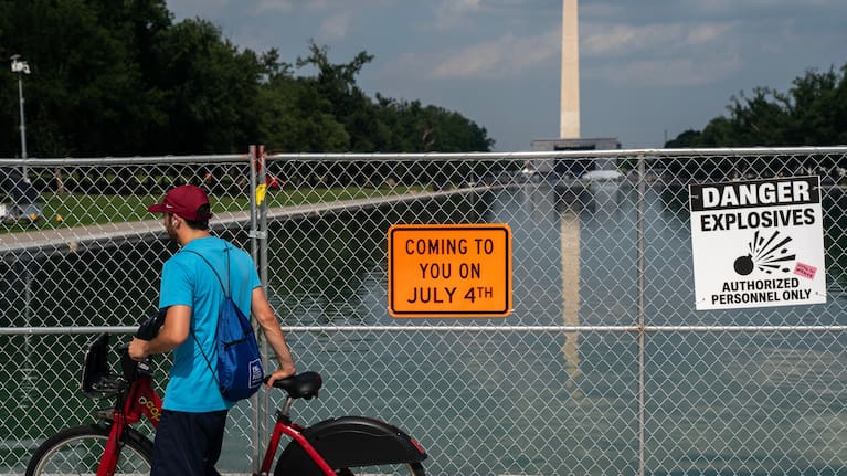 A man on a bike passes security fencing along the edge of the Lincoln Memorial Reflecting Pool ahead of America 250 July 4th celebration on the National Mall