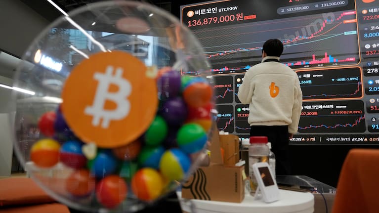 An employee watches an electronic signboard displaying the prices of Bitcoin and other cryptocurrencies at the lounge of Bithumb cryptocurrency exchange in Seoul, South Korea