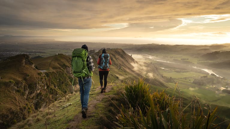 Backpackers walking on a mountain during sunrise. Te Mata Peak, Hawke´s Bay, New Zealand.