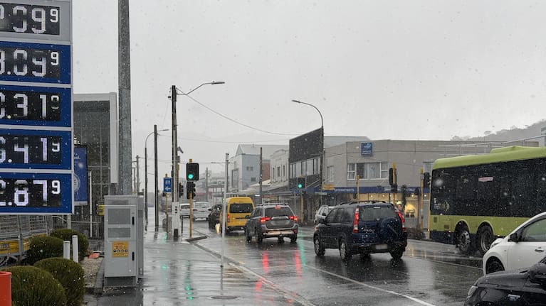 Cars driving through snow and sleet in Karori, Wellington.