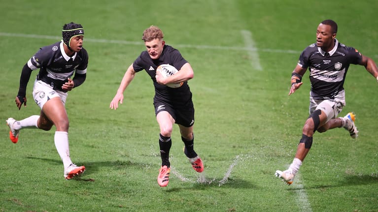 Damian McKenzie carries the ball against the Sharks on a waterlogged Kings Park pitch.