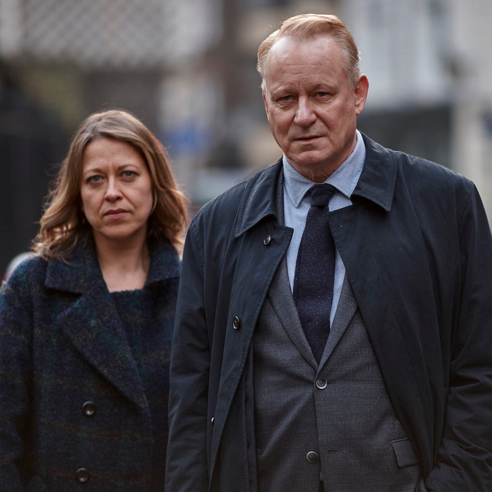 two people walking outdoors on an overcast day, looking serious and contemplative. two people walking outdoors on an overcast day, looking serious and contemplative.