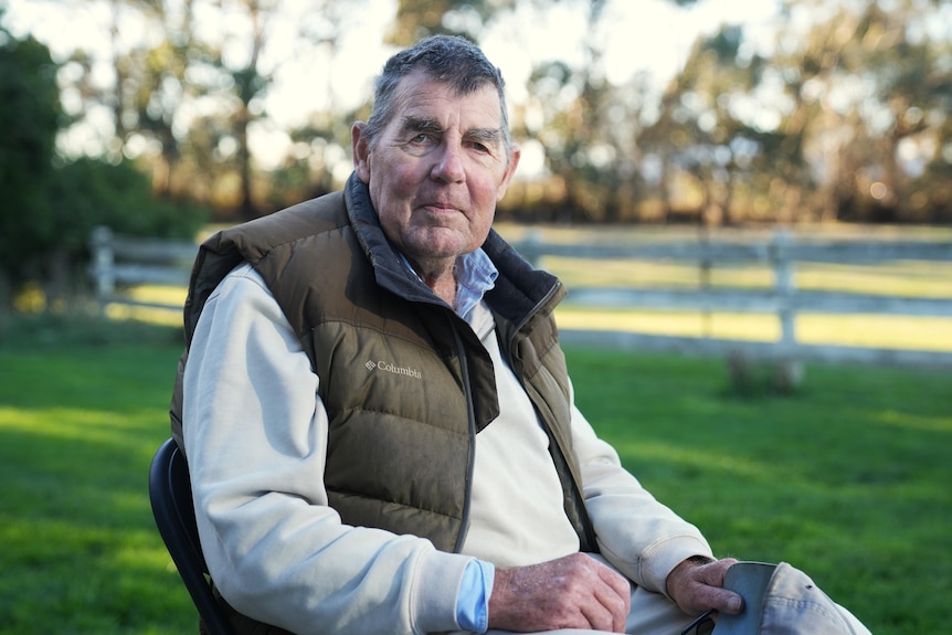 He sits in a chair on the front lawn of his property