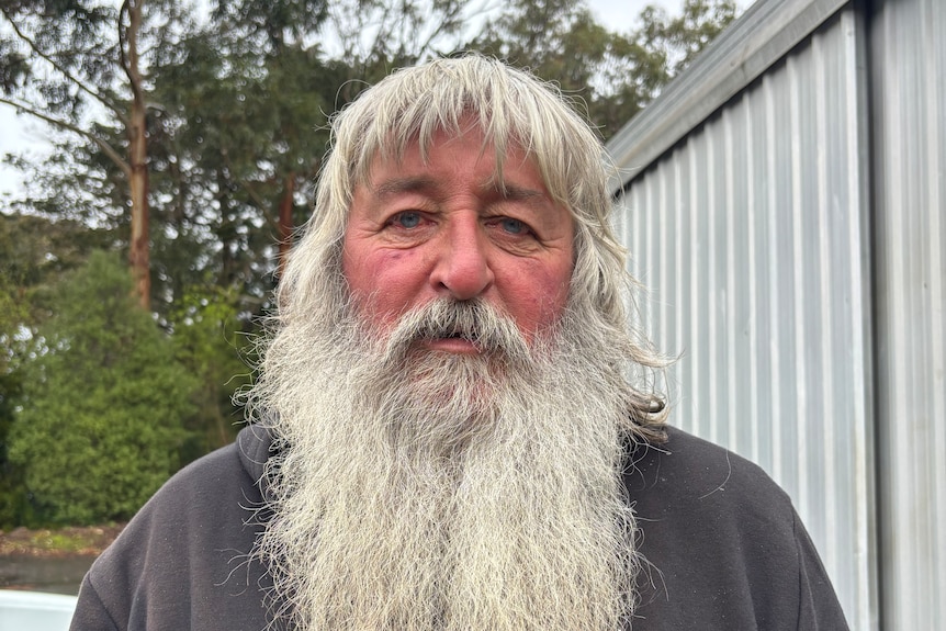 A portrait photo of a man with a long grey beard.