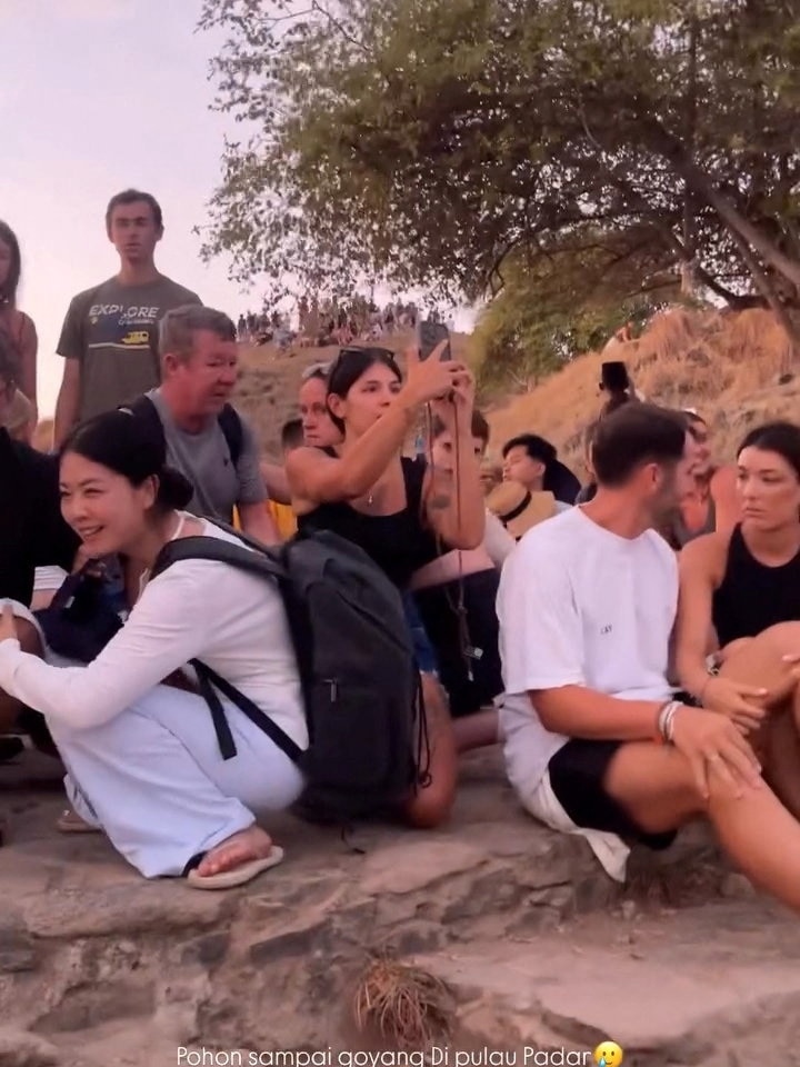 A group of people sitting with some talking to each other and taking photos